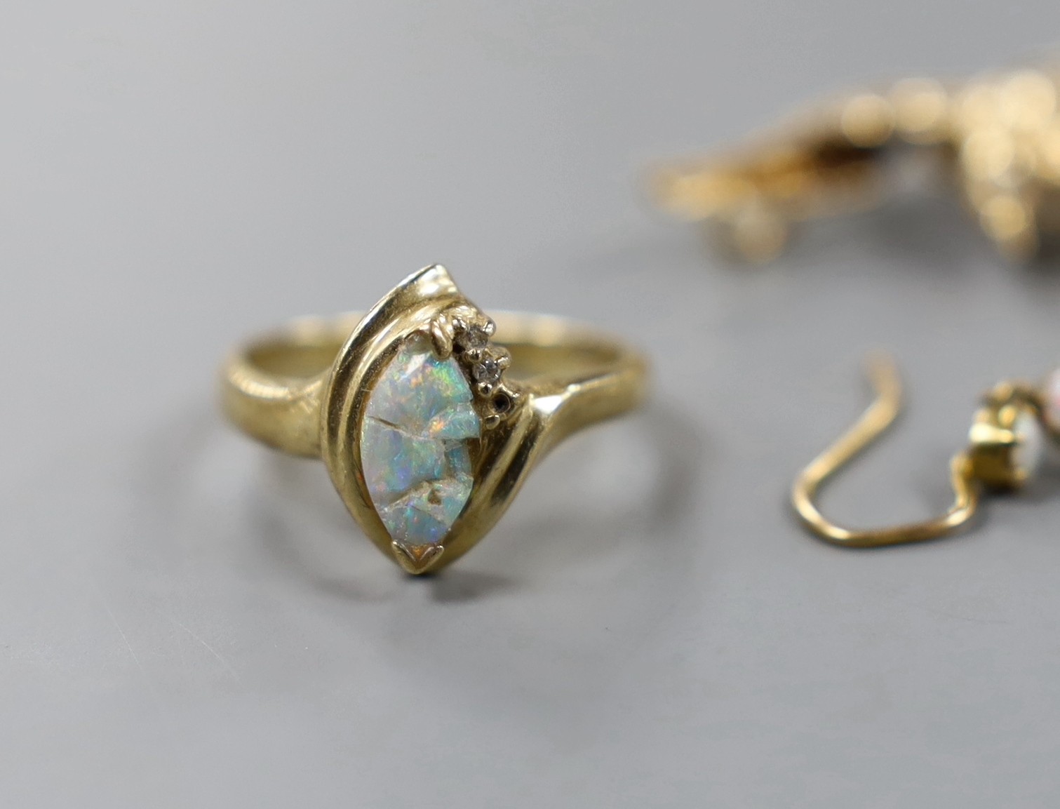A 14k and gem set 'bird in flight' brooch, 50mm, gross weight 4.1 grams, a 9k and white opal ring, pair of yellow metal and white opal drop earrings and a yellow metal and white opal 'butterfly' ring, gross 6.4 grams.